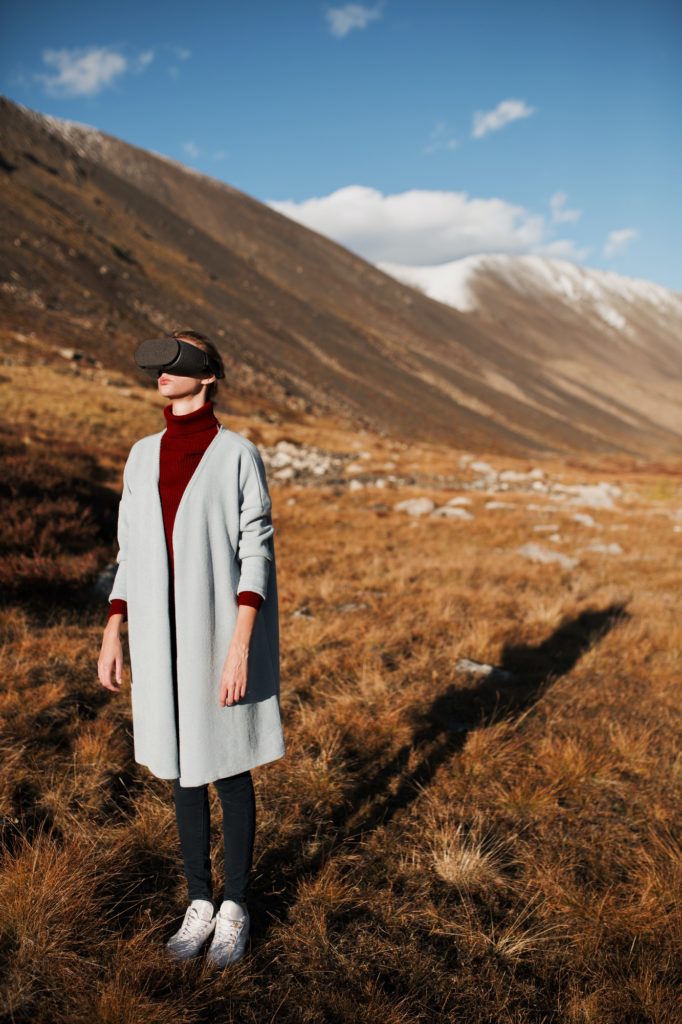 Woman In Virtual Reality. Mountain Landscape At Background.